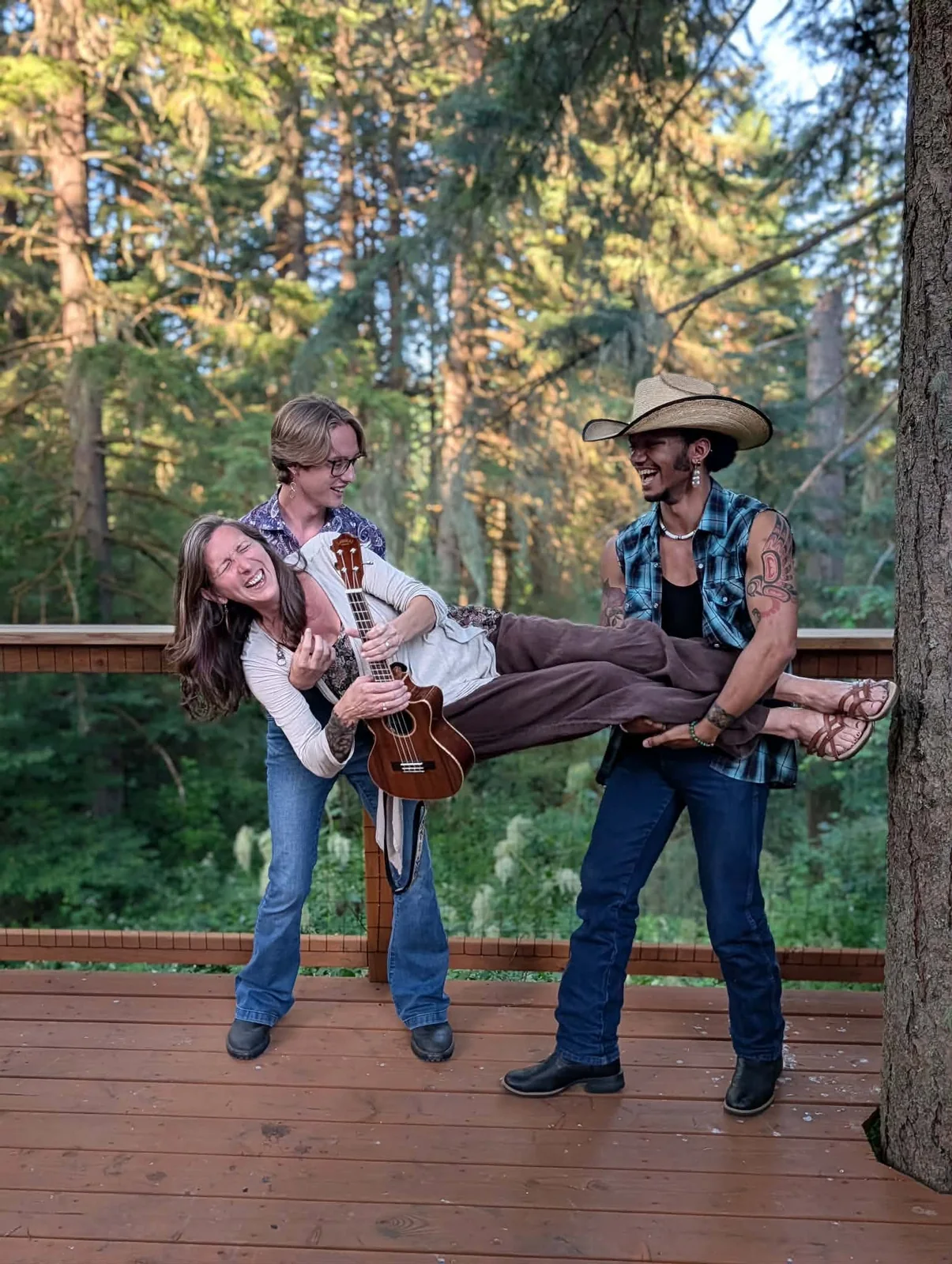 Cooper and Dakota laughing while holding Jen up during a playful Tree House Trio photo